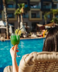 盖尼特拉Waves Aqua Resort的和玛格丽塔一起喝一杯绿饮料的女人