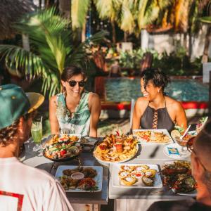 拉斯彭尼塔斯Casita de Playa BOMALU的一群人坐在桌子旁吃着食物