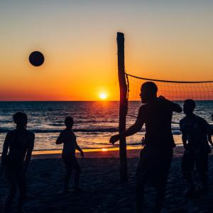 拉斯彭尼塔斯Casita de Playa BOMALU的一群人在日落时分在沙滩上打排球