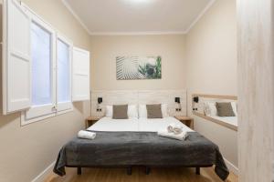 巴塞罗那AB Eixample Viladomat的一间卧室设有一张床和两个窗户。