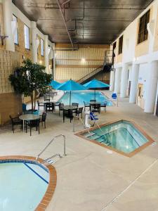 德卢斯海滨广场套房酒店的大楼内带桌椅的大型室内游泳池