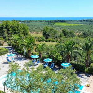 维耶斯泰Villa Amica的享有度假村的空中景致,设有蓝色的桌子和棕榈树