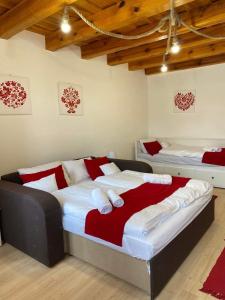 SZÍVES LAK的一间卧室配有两张红色和白色床单