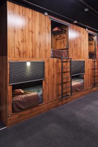 阿拉木图Gagarin Capsule Hotel的木墙内的房间,设有三张双层床