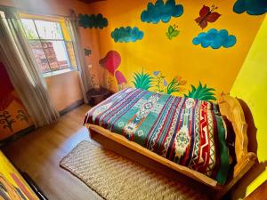 伊瓦拉富希奥特拉埃斯佩兰萨旅馆的一间卧室配有一张带彩色墙壁的床