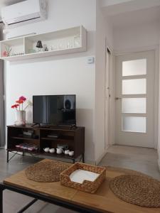 马德里卡拉班切卡斯蒂佐公寓的客厅配有桌子和电视