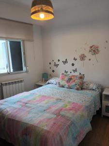 马德里卡拉班切卡斯蒂佐公寓的一间卧室配有一张带五颜六色棉被的床