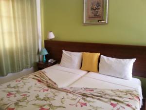 Rui VazQuinta Da Montanha的一间卧室配有一张带白色床单和黄色枕头的大床。