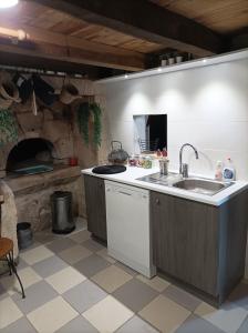 蒙索罗Gite des Perreyeurs - maison troglodyte avec vue sur Loire的厨房配有水槽和炉灶 顶部烤箱