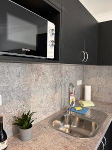 布莱德Grom Ribno Apartments的厨房柜台设有水槽和微波炉