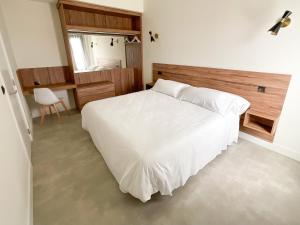 索托德拉马里纳Apartamentos La Canal的卧室配有白色的床和书桌