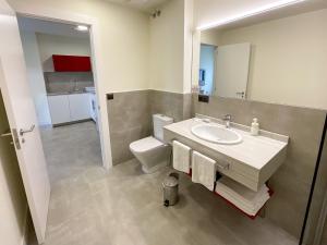索托德拉马里纳Apartamentos La Canal的一间带水槽、卫生间和镜子的浴室