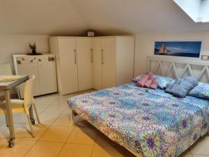 斯波托尔诺La Mansarda di Noi2的一间卧室配有一张床、一张桌子和橱柜