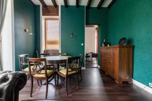 Le Patchouli Billard, Jardin & Confort的一间拥有绿色墙壁和桌椅的用餐室