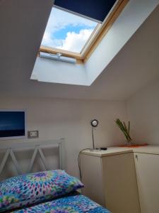 斯波托尔诺La Mansarda di Noi2的一间卧室设有天窗和一张床