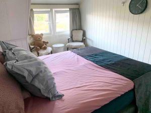 莫斯Dobbeltrom的一间卧室配有一张床,椅子上摆放着泰迪熊