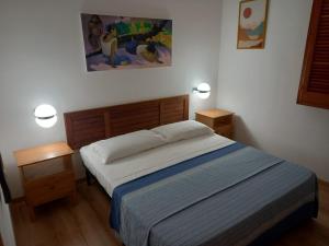 桑尼科拉Villetta Crumisi的一间卧室配有一张带2个床头柜和2盏灯的床。