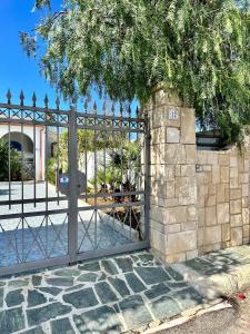托雷奇安卡Villa azzurra的铁门,石墙和一棵树