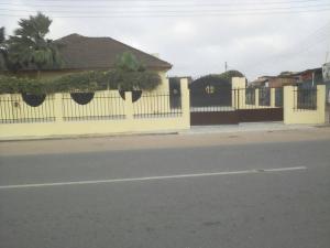 SpintexAccra Service Villas- 3的一条黄围栏,上面有植物,在街道旁