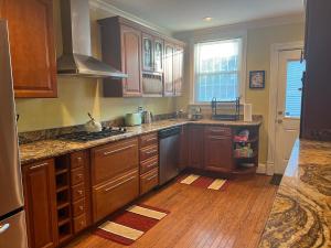 华盛顿3 Level 4 Bedroom Home w/ Parking in Adams Morgan的厨房配有木制橱柜和炉灶烤箱。