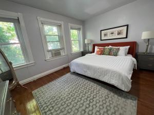 华盛顿3 Level 4 Bedroom Home w/ Parking in Adams Morgan的一间卧室设有床、两个窗户和地毯。