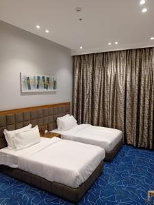 利雅德نمار هوم للاجنحة المخدومة -طويق的酒店客房设有两张床和窗户。
