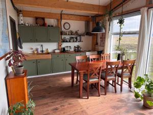 阿克拉内斯Rustic Farmhouse - Narfasel的厨房配有绿色橱柜和木桌及椅子
