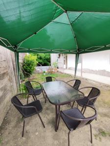 博尔若米ATI MTA - Eco Hostel的绿伞下的桌椅