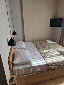 谢赫维蒂利Home Shekvetili的一间卧室配有一张带白色床单和一盏灯的床。
