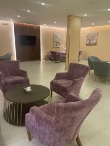 塔伊夫Fiori Hotels的大堂设有椅子、桌子和电视。