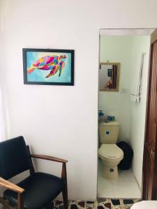 佩雷拉Hostal la 18的一间带卫生间的浴室和墙上的照片