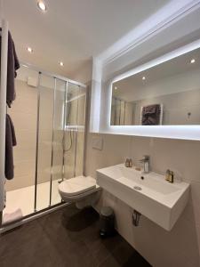 诺德奈Hotel Paula Norderney的一间带水槽、卫生间和镜子的浴室