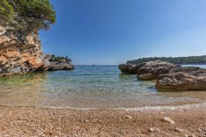 扎通Villa and Apartments Milos的晴天,海滩上拥有岩石和海洋