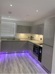 巴塞尔顿G2 Luxury Rooms in a Shared House的地板上的厨房配有紫色灯