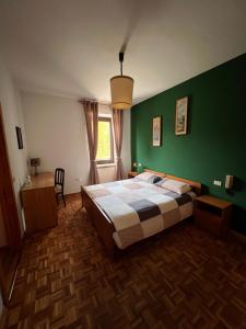 Albergo Monte RovereMonterovere的一间卧室设有一张床和绿色的墙壁
