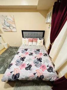 伊洛伊洛* *K Irresistable value for 3的一间卧室配有一张带花卉床罩的床