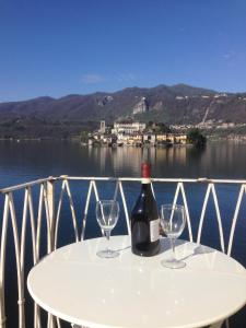奥尔塔圣朱利奥-Ortaflats- Appartamento L'Angolo的一张桌子上放着一瓶葡萄酒,放上两杯