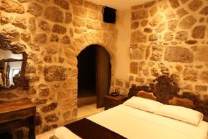 马尔丁Mardin Bey Konağı Hotel的一间卧室设有一张床和石墙