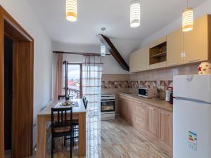 布拉索夫Apartamente Simona Brasov的厨房配有木制橱柜和白色冰箱。