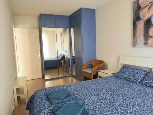 马赛Appartement Marseille Vacances的一间卧室配有蓝色的床和镜子