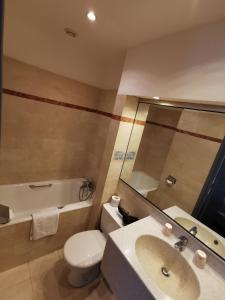 埃特勒塔悬崖酒店的浴室配有盥洗盆、卫生间和浴缸。