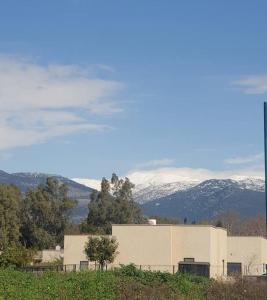 哈戈什里姆בית בקיבוץ的一座山丘上的建筑,背景是白雪 ⁇ 的山脉