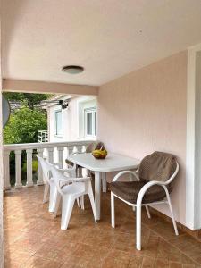 威尔帕扎Village house Iva的阳台上配有白色的桌椅