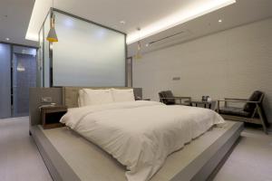 釜山HOTEL YUNA Business的卧室配有一张大屏幕白色大床