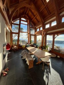 Pender IslandCliff Top Family Home Over Looking the Ocean的大房间设有桌子和一些窗户