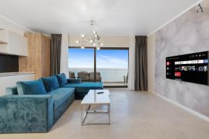 北马马亚-讷沃达里Gioia Sea View的客厅配有蓝色沙发,享有海景