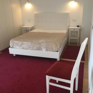 布拉加ÍSIS Guest House的卧室配有白色的床和椅子