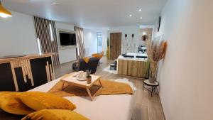 La BasséeGrand Studio magnifique avec Spa privatif illimité的客厅以及带床和桌子的厨房。