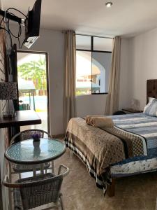 伊察Huacachina Desert House的一间卧室配有一张床、一张桌子和一面镜子