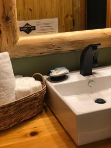 Summit Lake苏米特湖畔旅舍的一间带水槽和一篮毛巾的浴室